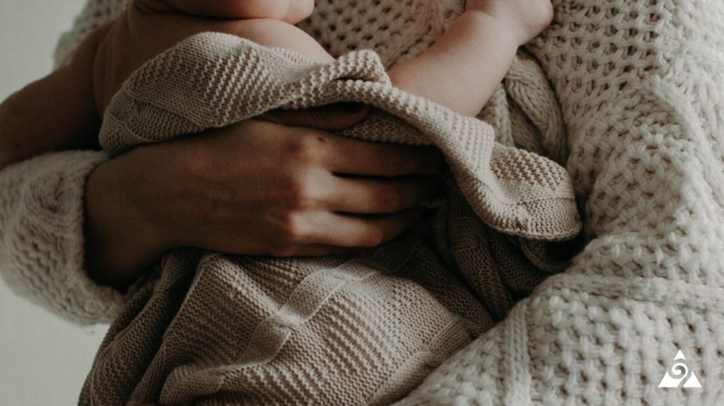 mother holding baby in blanket