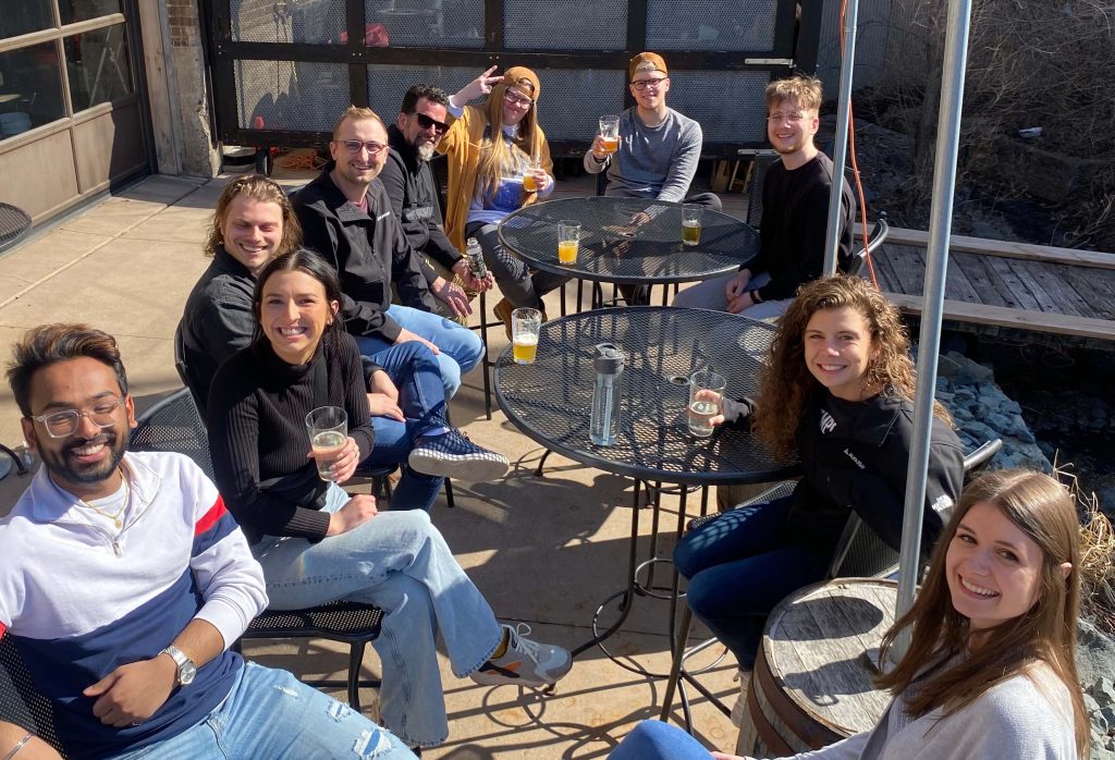 Augurian team having happy hour on an outdoor patio